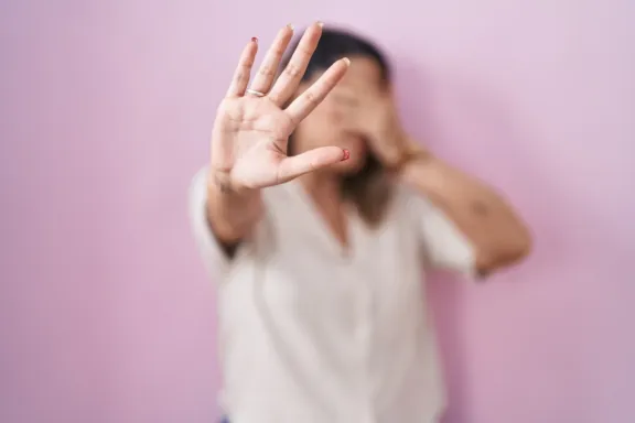 mujer se tapa con la mano ante los abusos sexuales