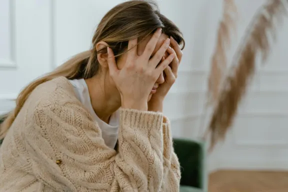 mujer atormentada psicológicamente con sus manos tapando la cabeza